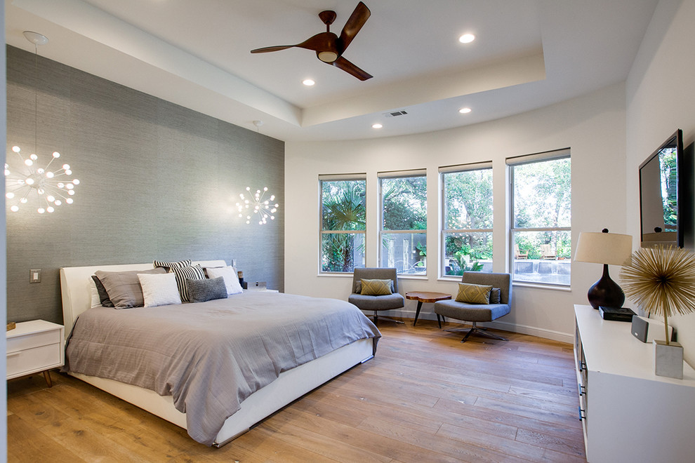 Großes Modernes Hauptschlafzimmer ohne Kamin mit weißer Wandfarbe und hellem Holzboden in Dallas