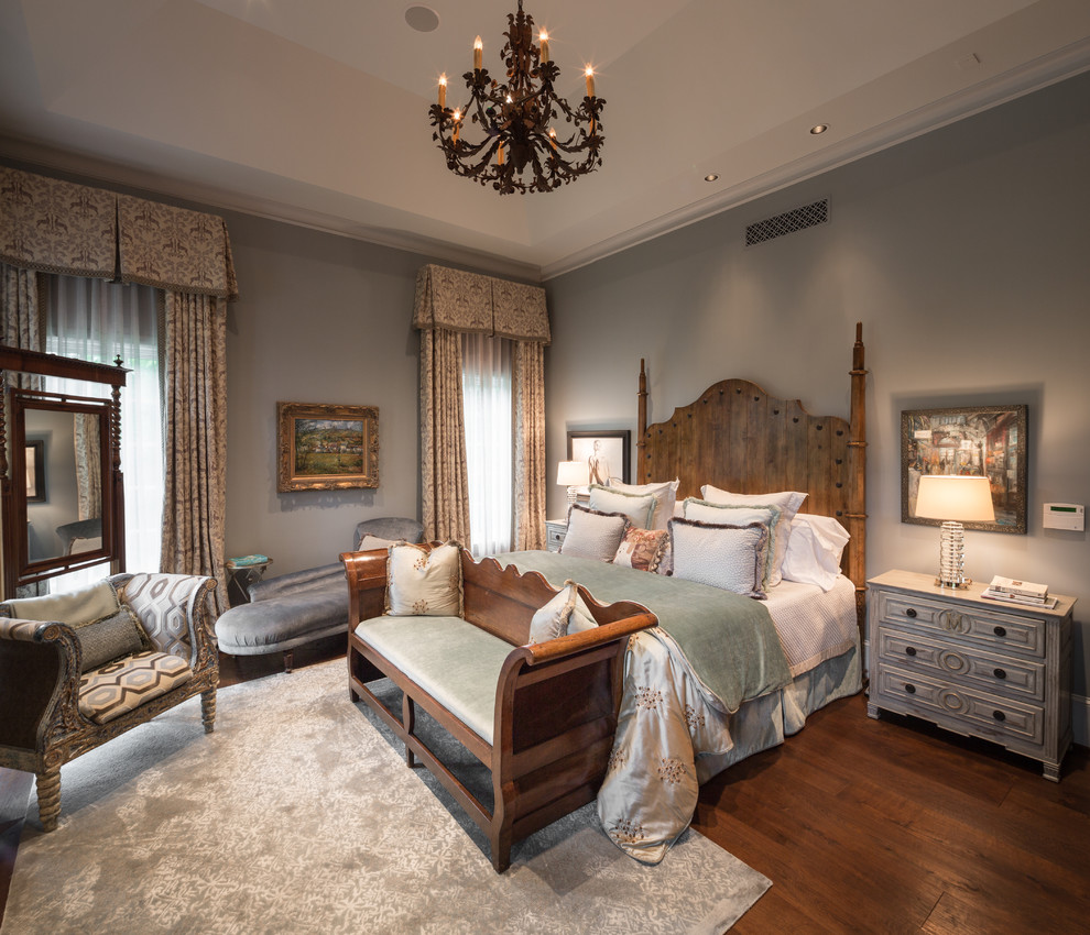 Modelo de dormitorio principal clásico con paredes grises, suelo de madera en tonos medios y suelo marrón