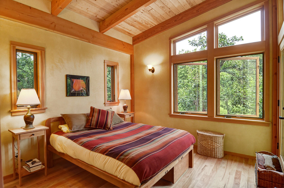 Rustik inredning av ett sovrum, med beige väggar och ljust trägolv