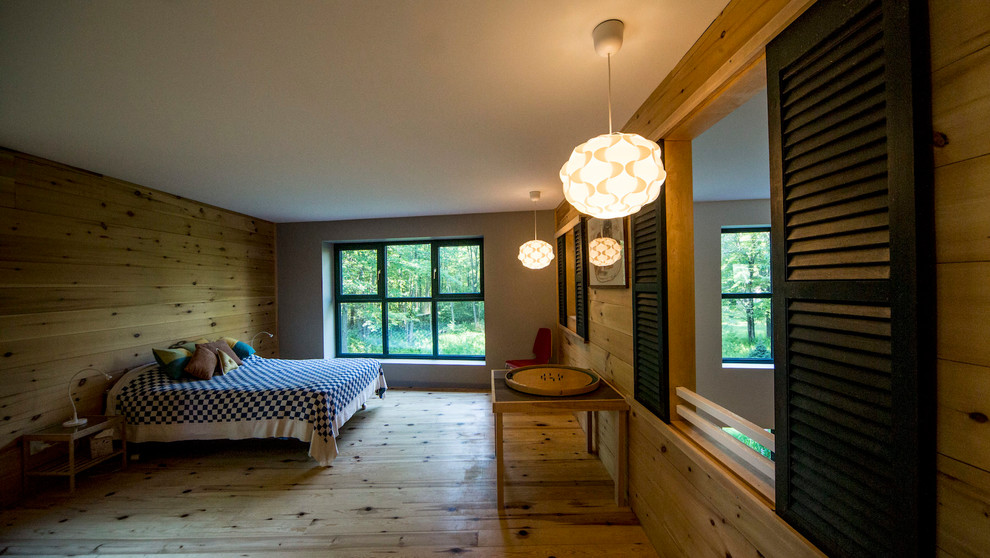 Modelo de dormitorio principal rural de tamaño medio con paredes multicolor, suelo de cemento y suelo gris