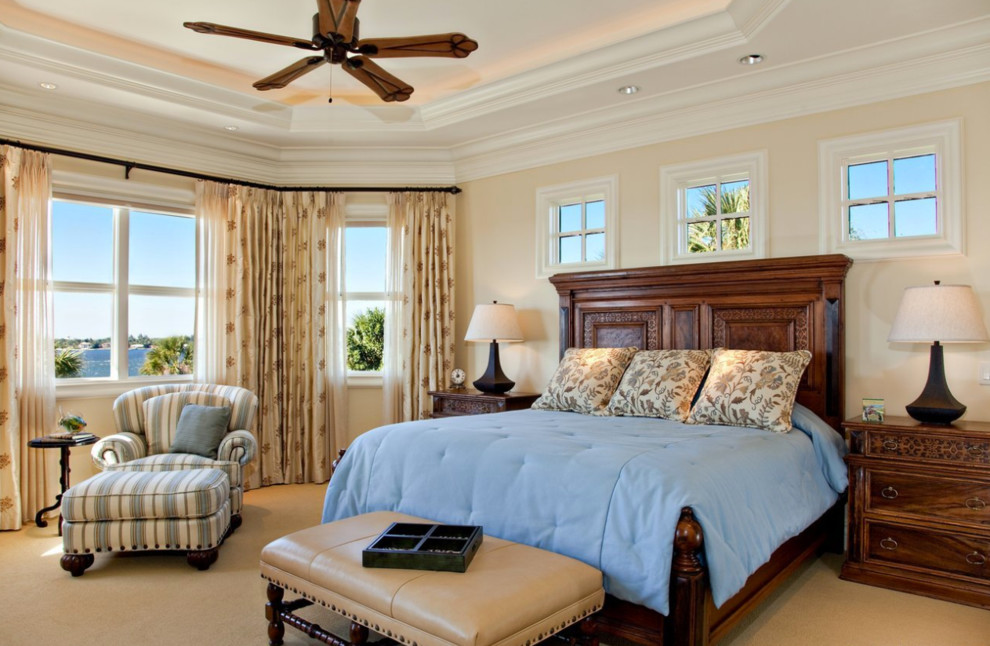 Imagen de dormitorio principal costero grande sin chimenea con paredes amarillas, moqueta y suelo beige
