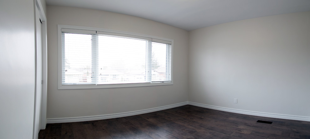 Cette photo montre une chambre chic de taille moyenne avec un mur blanc, un sol en bois brun et un sol marron.