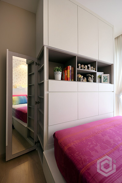 Cette image montre une petite chambre d'amis minimaliste avec un mur blanc.
