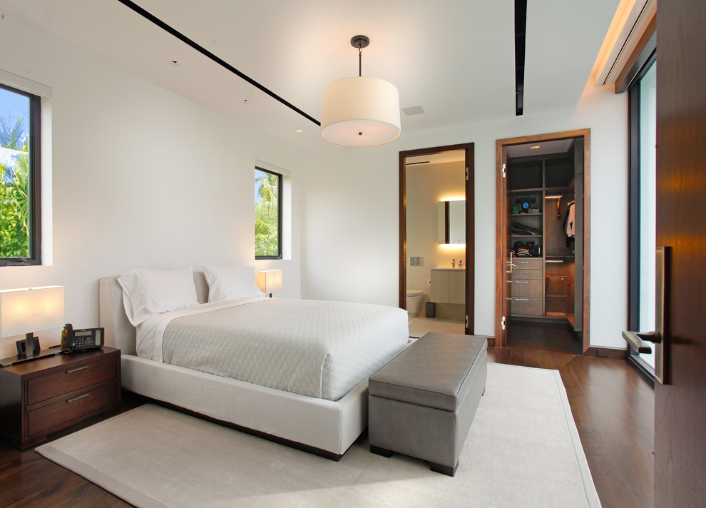 Imagen de habitación de invitados moderna de tamaño medio con paredes blancas, suelo de madera en tonos medios y suelo marrón