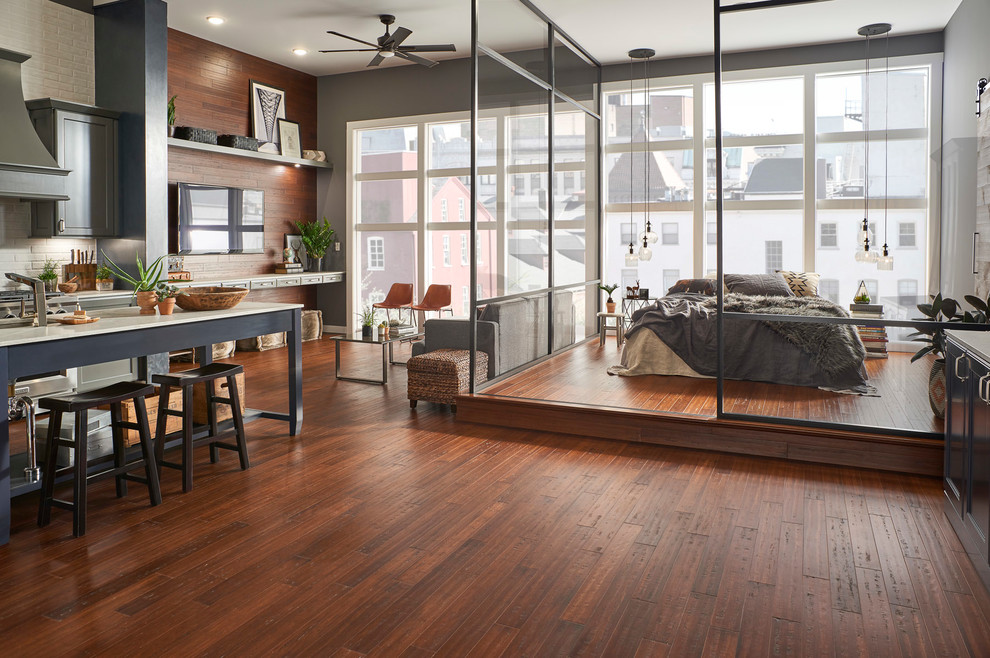 Foto di una camera da letto stile loft moderna con pavimento in bambù e pavimento marrone