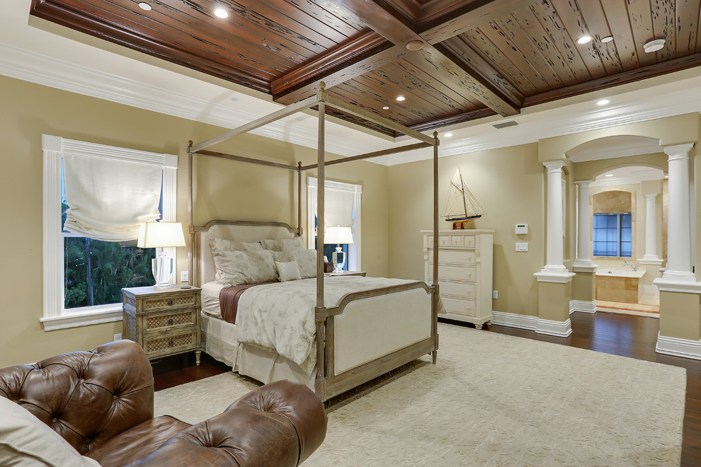 This is an example of a large classic master bedroom in Tampa with beige walls, dark hardwood flooring, no fireplace and brown floors.