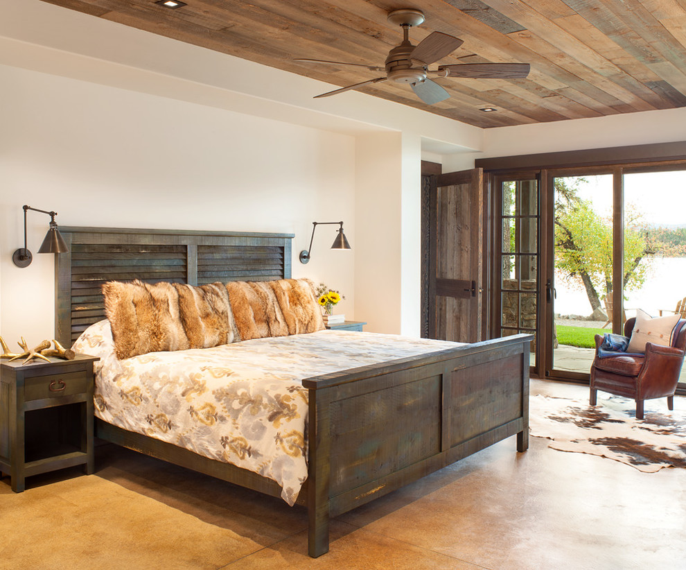 Inspiration for a large rustic master bedroom in Seattle with white walls and concrete flooring.