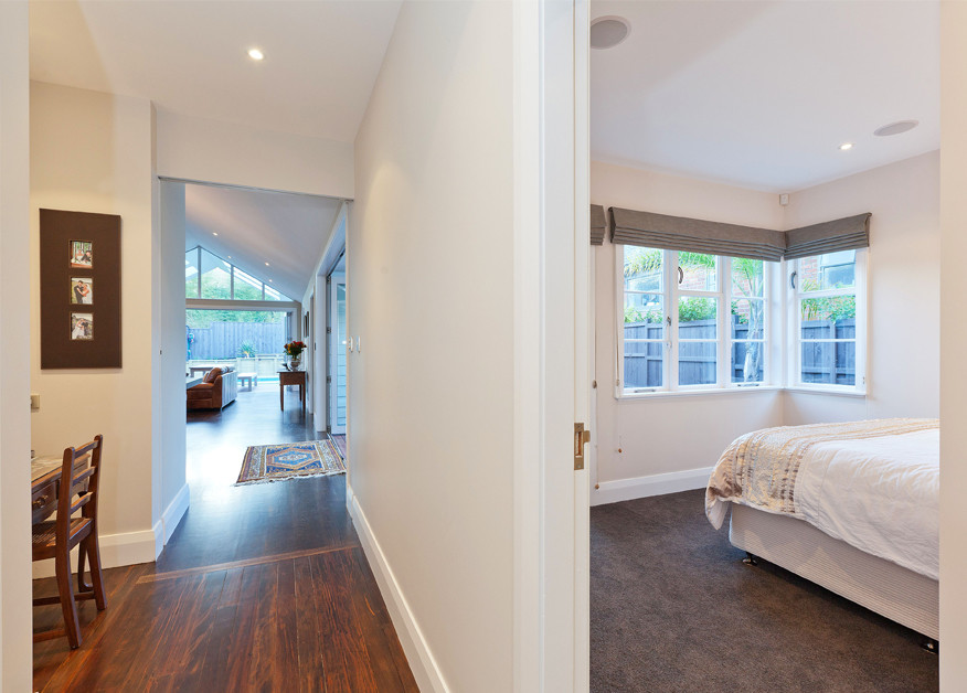 Immagine di una camera degli ospiti design di medie dimensioni con pareti beige, moquette e pavimento grigio