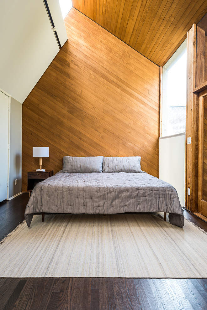 Exemple d'une chambre tendance avec un mur blanc et parquet foncé.