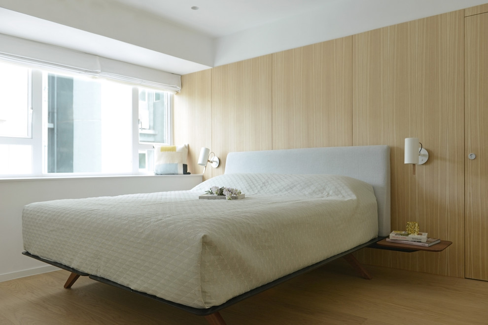 Ejemplo de dormitorio escandinavo con paredes beige y suelo de madera clara