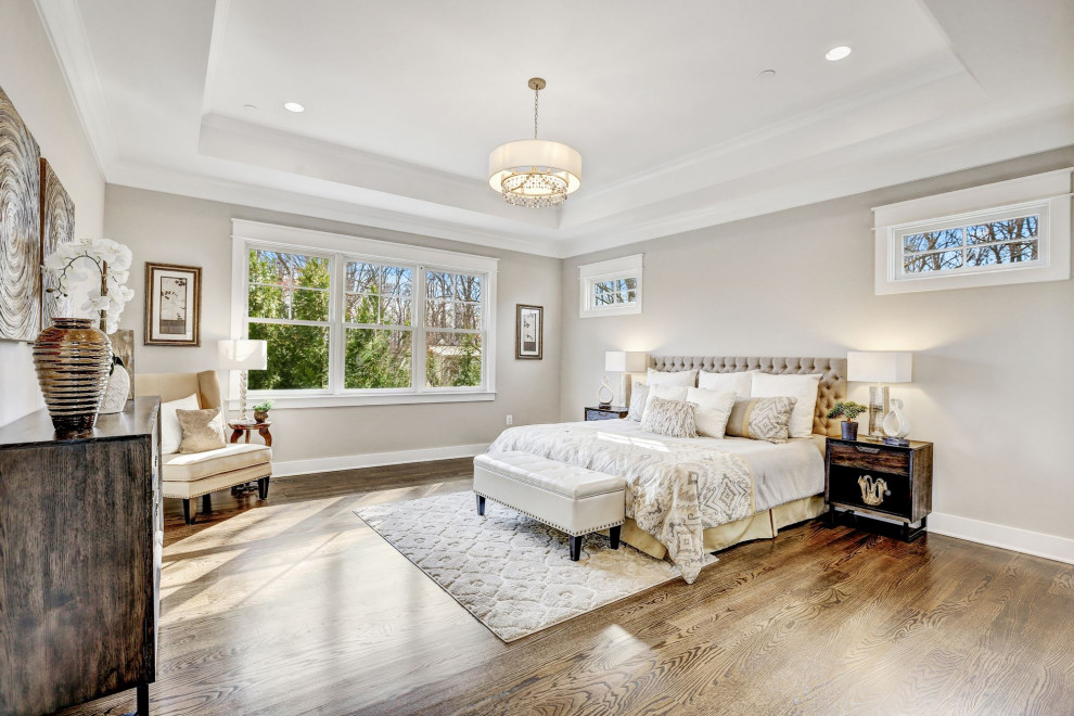 Imagen de dormitorio principal clásico renovado grande con paredes grises y suelo marrón
