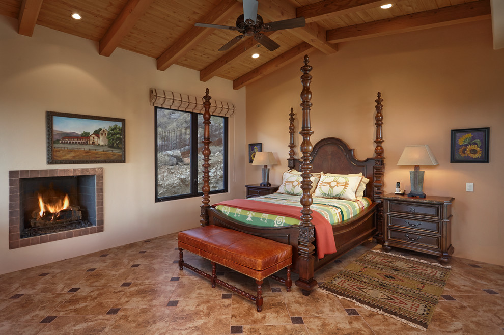 フェニックスにある広いサンタフェスタイルのおしゃれな寝室 (ベージュの壁、磁器タイルの床、標準型暖炉、タイルの暖炉まわり) のインテリア