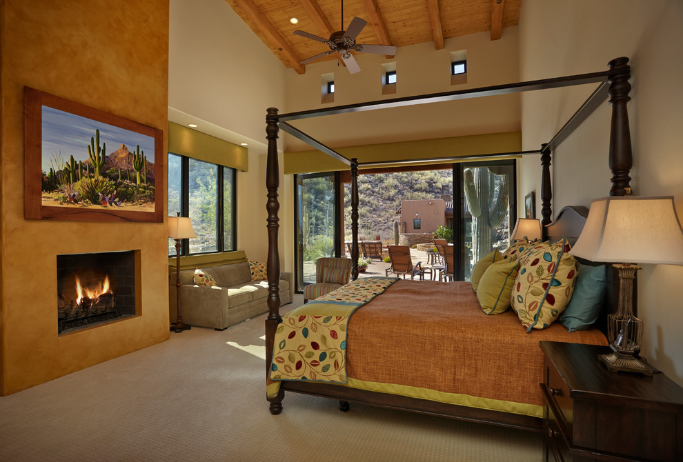 На фото: большая хозяйская спальня в стиле фьюжн с бежевыми стенами, ковровым покрытием, стандартным камином и фасадом камина из штукатурки с