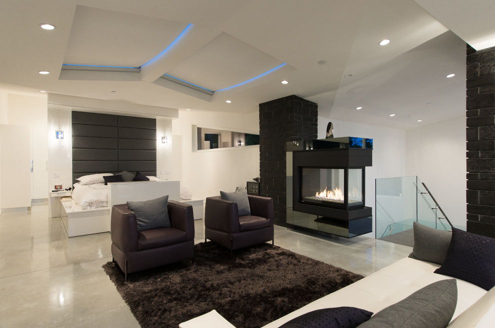 Modernes Hauptschlafzimmer mit weißer Wandfarbe, Betonboden, Tunnelkamin und gefliester Kaminumrandung in Vancouver