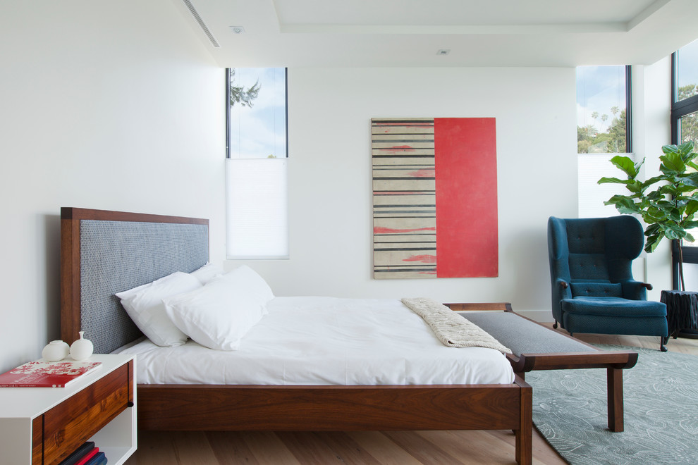 Großes Modernes Hauptschlafzimmer ohne Kamin mit weißer Wandfarbe und hellem Holzboden in Los Angeles