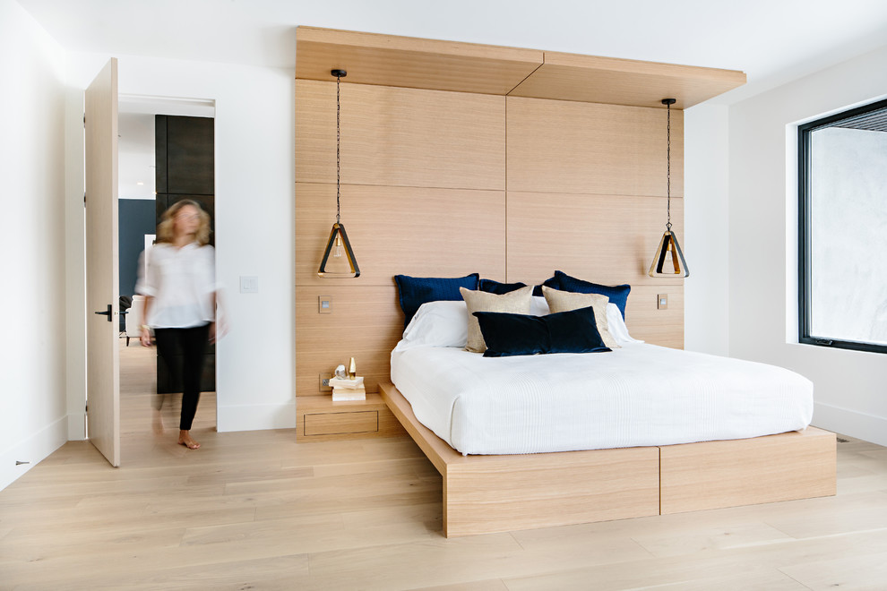 Diseño de dormitorio contemporáneo sin chimenea con paredes blancas, suelo de madera clara y suelo beige