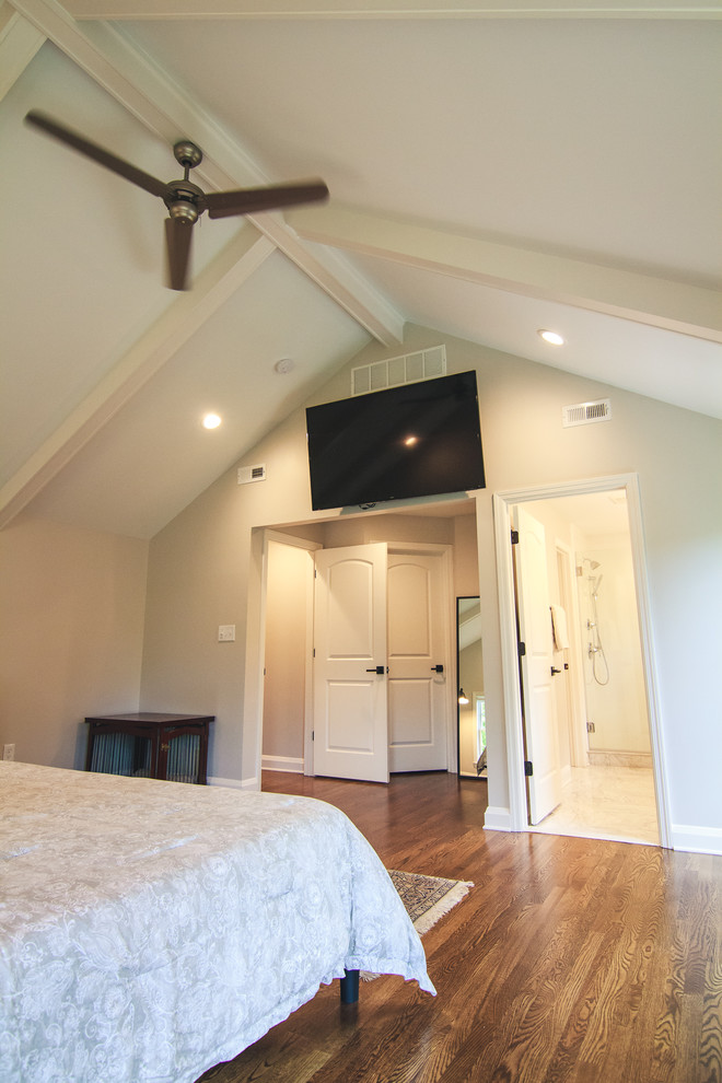 Ejemplo de dormitorio principal clásico grande sin chimenea con paredes beige, suelo de madera en tonos medios y suelo marrón