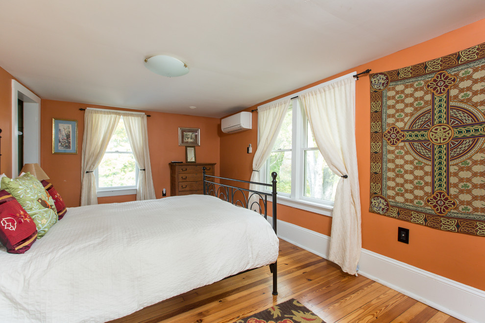 ワシントンD.C.にある中くらいなカントリー風のおしゃれな主寝室 (オレンジの壁、淡色無垢フローリング)