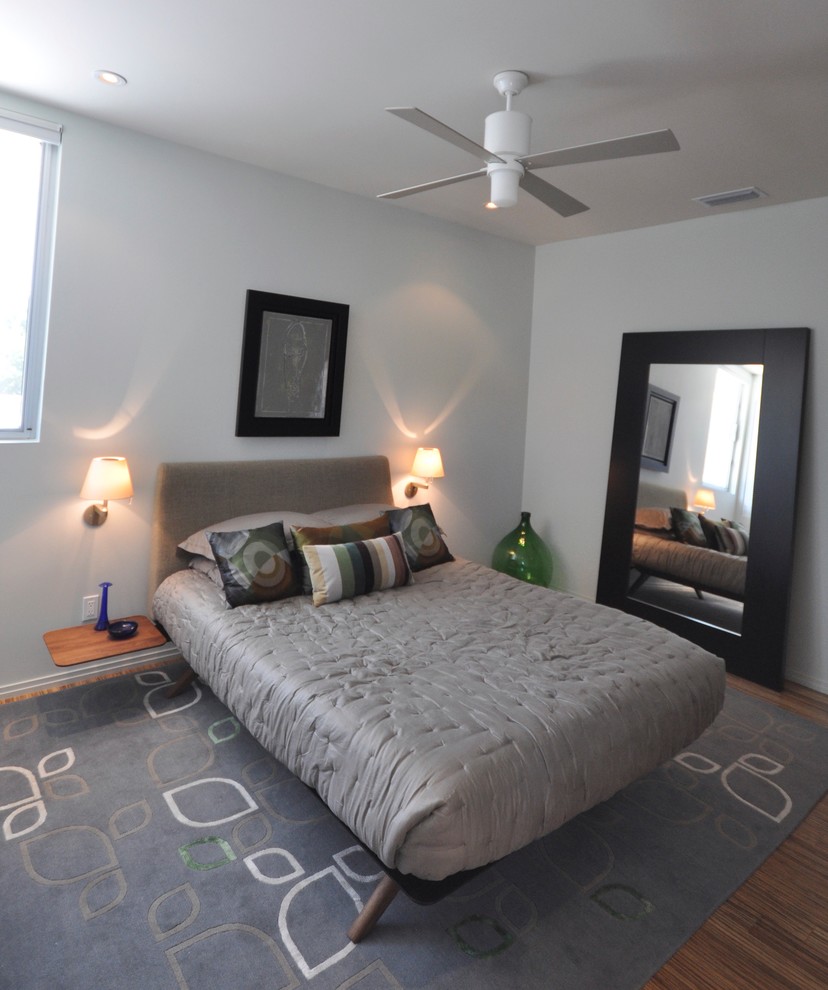 Medium sized modern guest bedroom in Austin with grey walls and medium hardwood flooring.