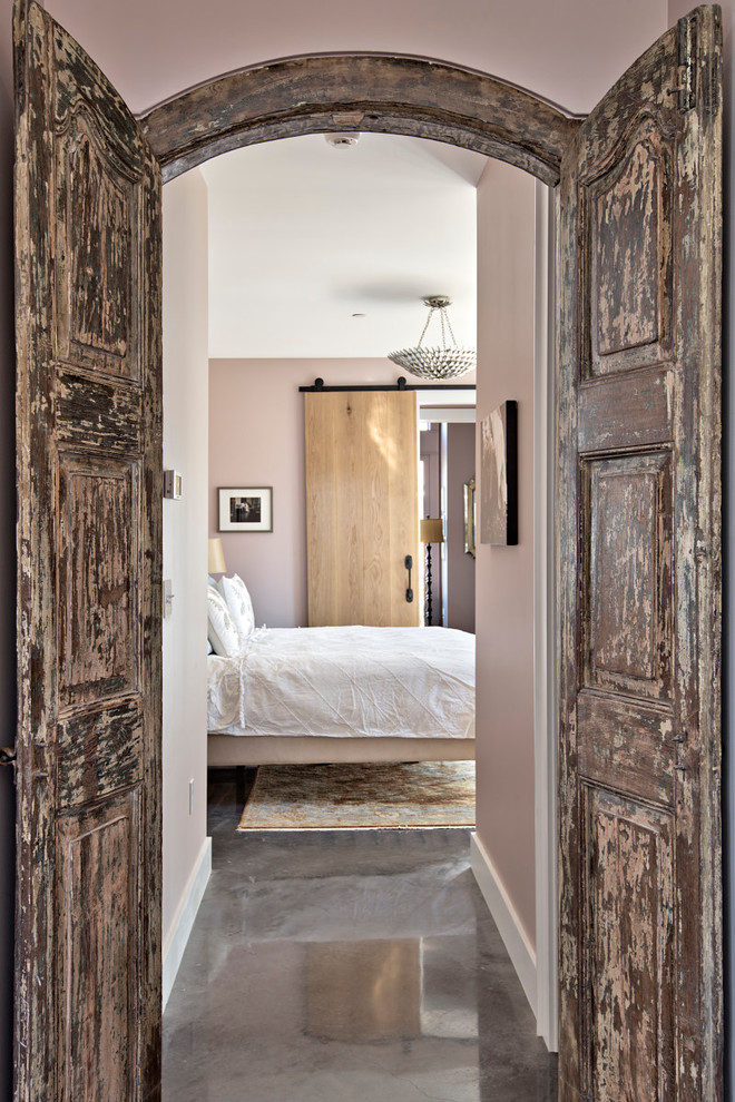 Imagen de dormitorio principal tradicional renovado grande con suelo de cemento, suelo gris y paredes rosas