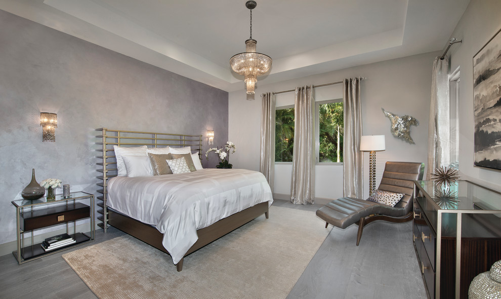 Large contemporary master and grey and silver bedroom in Miami with grey walls and medium hardwood flooring.
