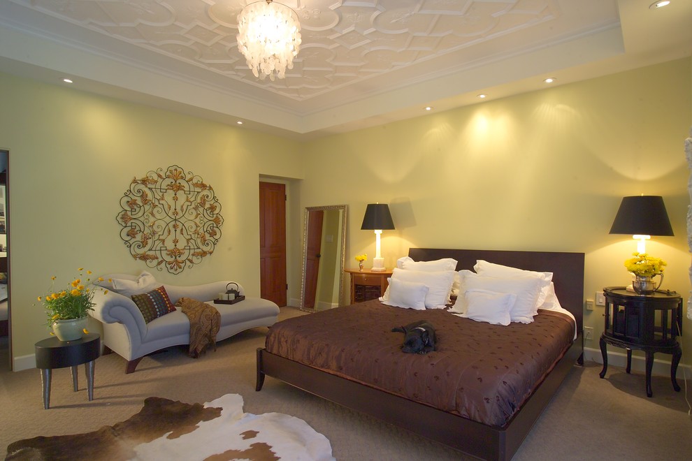 На фото: большая хозяйская спальня в классическом стиле с желтыми стенами, ковровым покрытием, стандартным камином, фасадом камина из металла и бежевым полом с