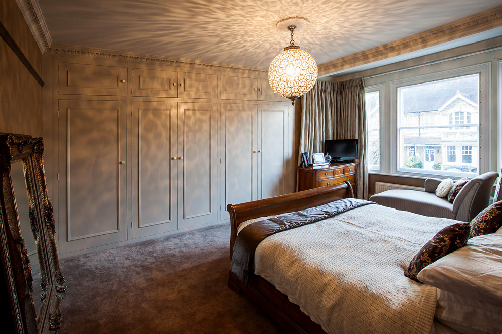 Klassisches Schlafzimmer mit beiger Wandfarbe und Teppichboden in Oxfordshire