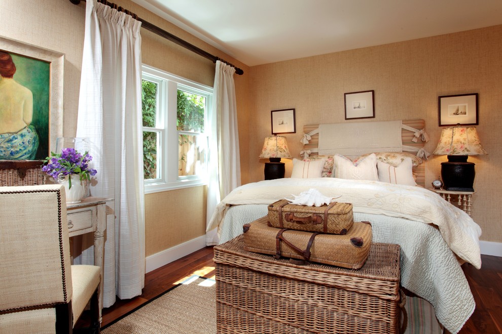 Shabby chic-inspirerad inredning av ett sovrum, med beige väggar och mörkt trägolv