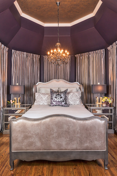 Klassisches Hauptschlafzimmer mit lila Wandfarbe und hellem Holzboden in Austin