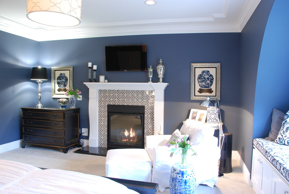 Großes Landhaus Hauptschlafzimmer mit blauer Wandfarbe, Teppichboden, Kamin, gefliester Kaminumrandung und weißem Boden in Richmond