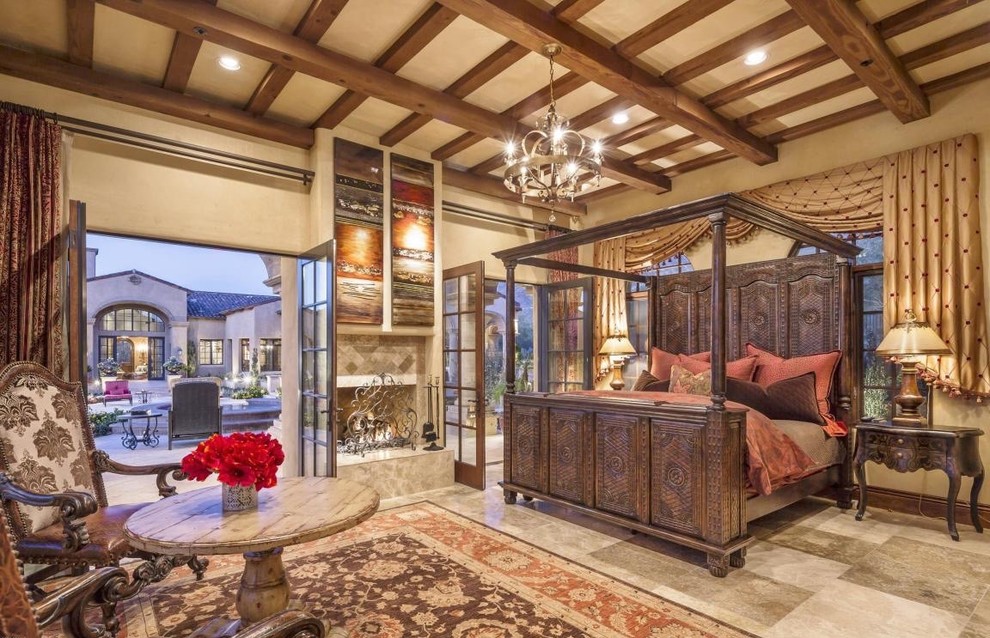 フェニックスにある広い地中海スタイルのおしゃれな客用寝室 (ベージュの壁、セラミックタイルの床、標準型暖炉、石材の暖炉まわり)