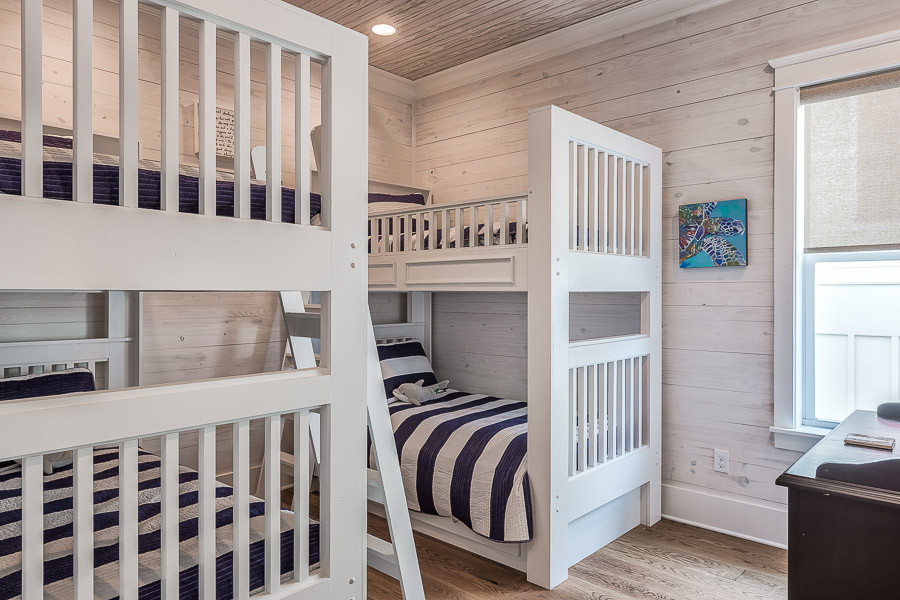 Idee per una camera degli ospiti stile marinaro di medie dimensioni con pareti beige, pavimento in legno massello medio e nessun camino