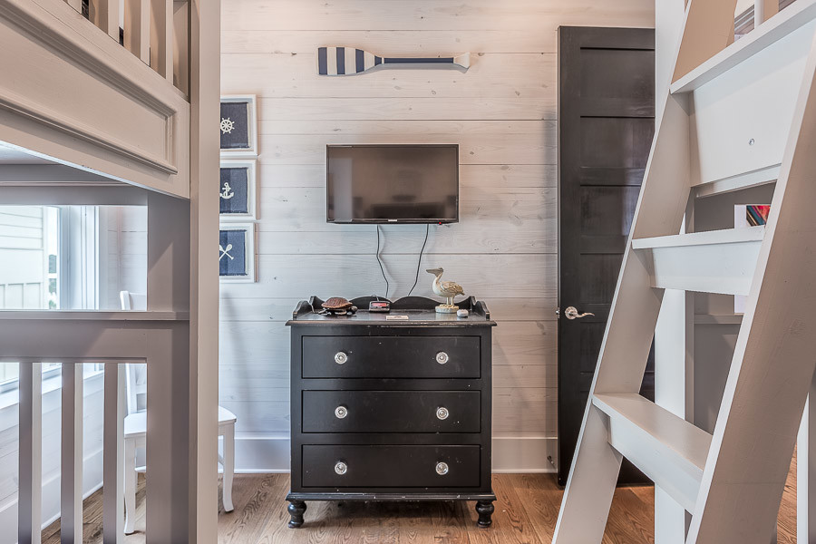 Imagen de habitación de invitados marinera de tamaño medio sin chimenea con paredes beige y suelo de madera en tonos medios