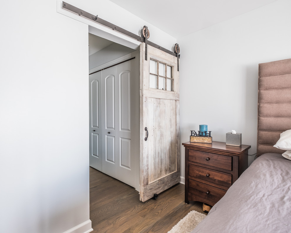 Exemple d'une chambre d'amis chic de taille moyenne avec un mur gris, un sol en bois brun, aucune cheminée et un sol marron.