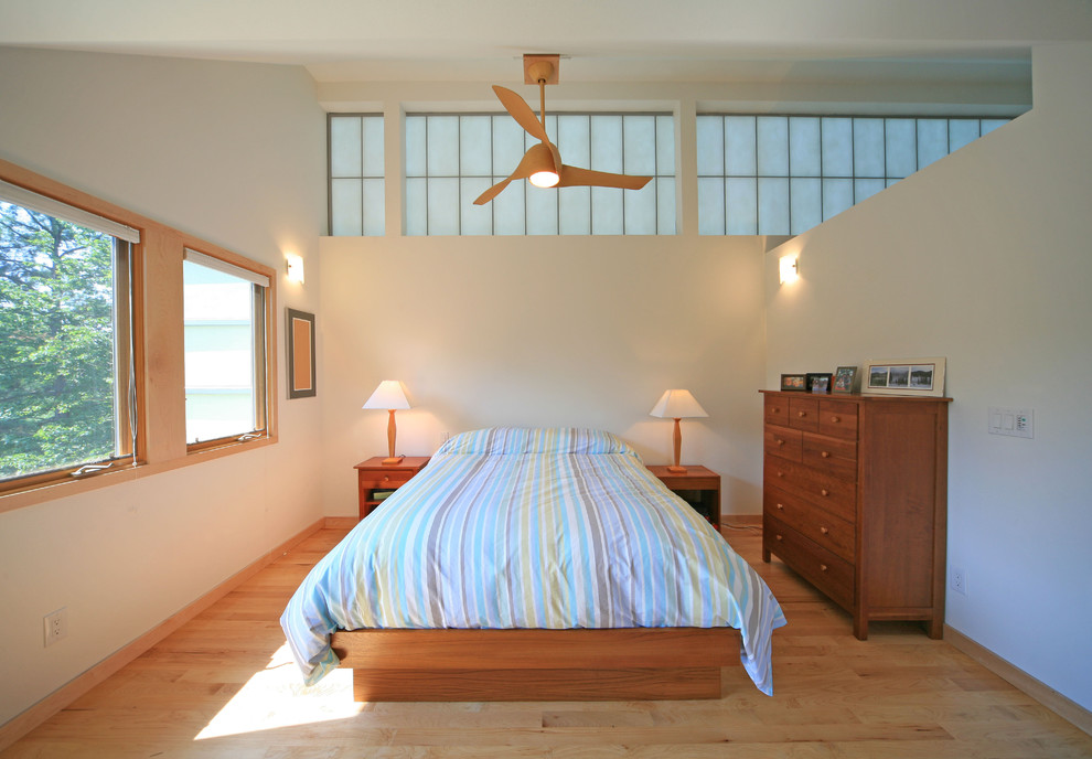 Idées déco pour une chambre contemporaine avec un mur blanc et un sol en bois brun.