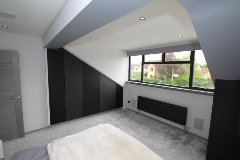 Example of a mid-sized trendy master bedroom design in Oxfordshire with gray walls