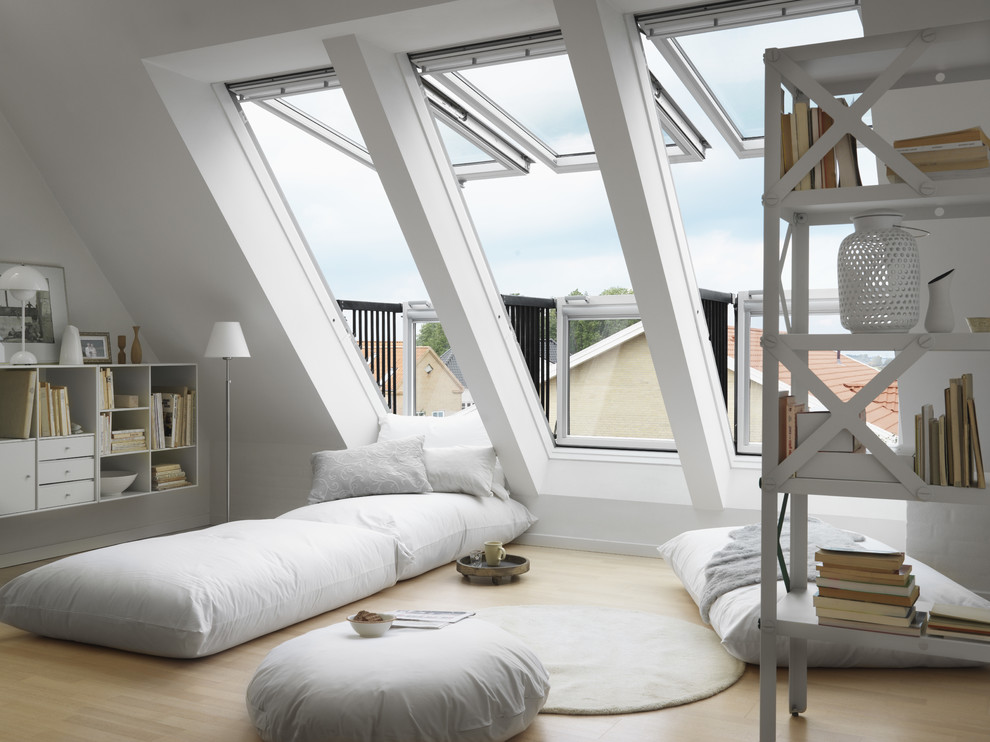 Imagen de habitación de invitados costera de tamaño medio con paredes blancas y suelo de madera clara