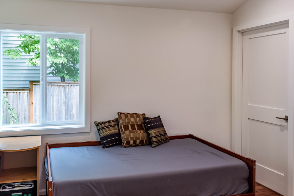 Medium sized traditional guest bedroom in Seattle with white walls, vinyl flooring, brown floors and a vaulted ceiling.