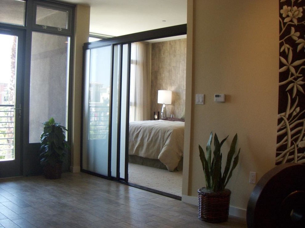 Foto de dormitorio tipo loft contemporáneo grande con paredes beige y suelo de madera clara