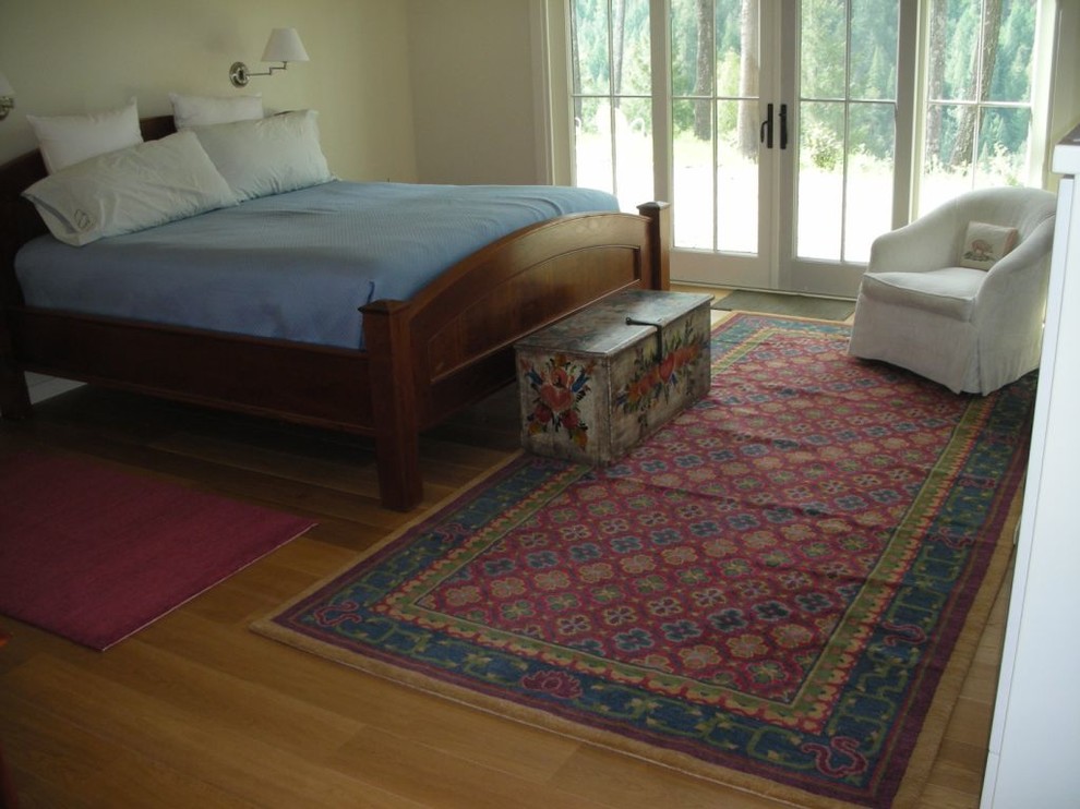 Inspiration for a world-inspired master bedroom in Burlington with beige walls and light hardwood flooring.