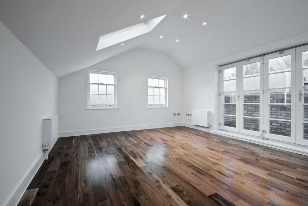 Mittelgroßes Modernes Schlafzimmer im Loft-Style mit weißer Wandfarbe und dunklem Holzboden in London
