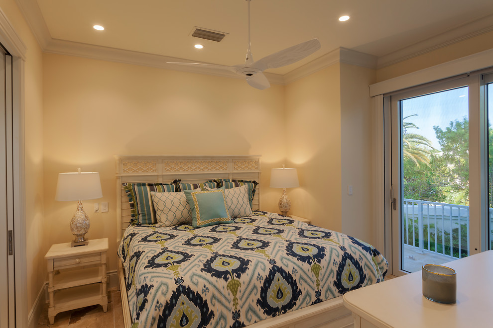 Ejemplo de habitación de invitados costera grande con paredes beige, suelo de travertino y suelo beige