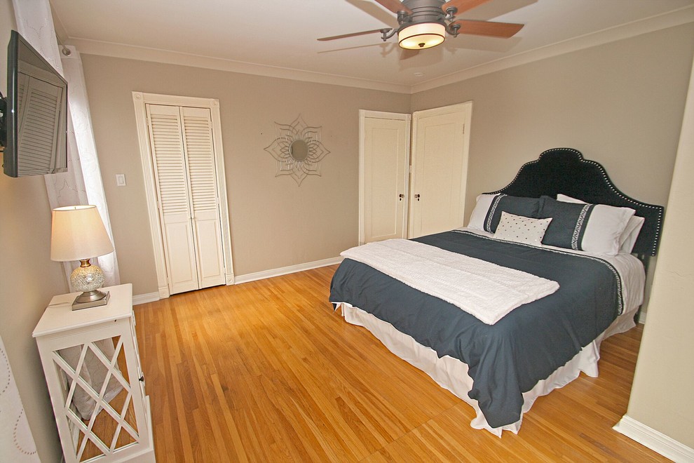 Cette photo montre une chambre chic de taille moyenne avec un mur beige, un sol en bois brun et aucune cheminée.
