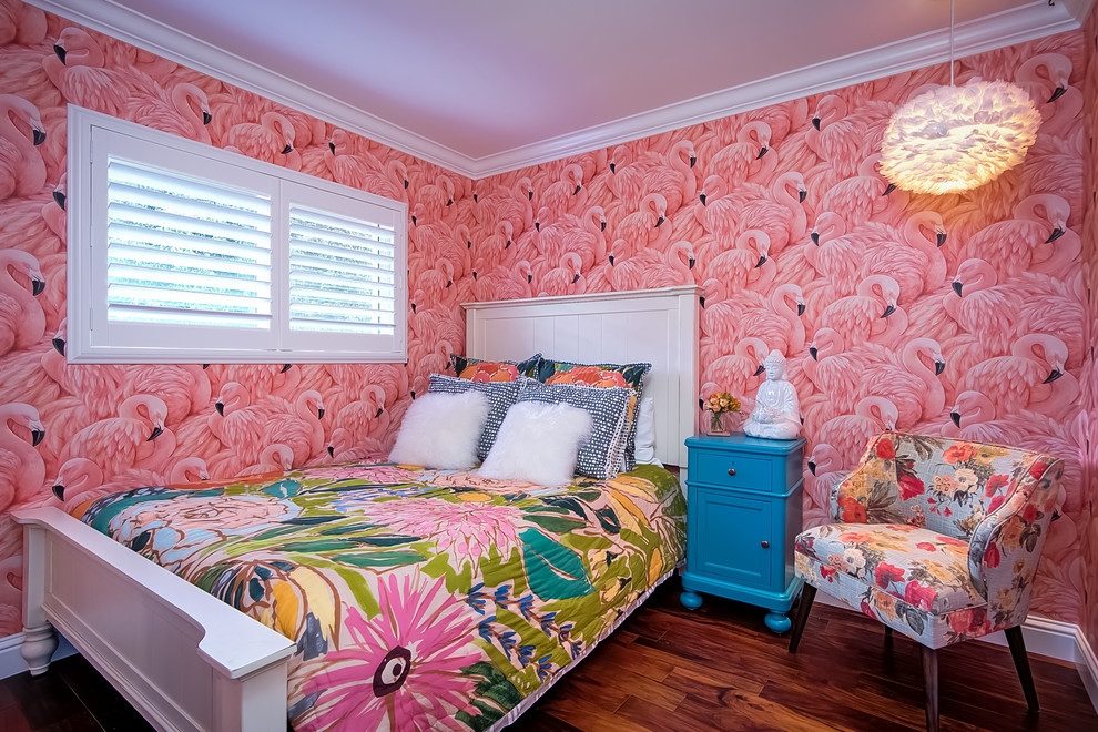 Cette image montre une petite chambre d'amis ethnique avec un mur rose et un sol en bois brun.