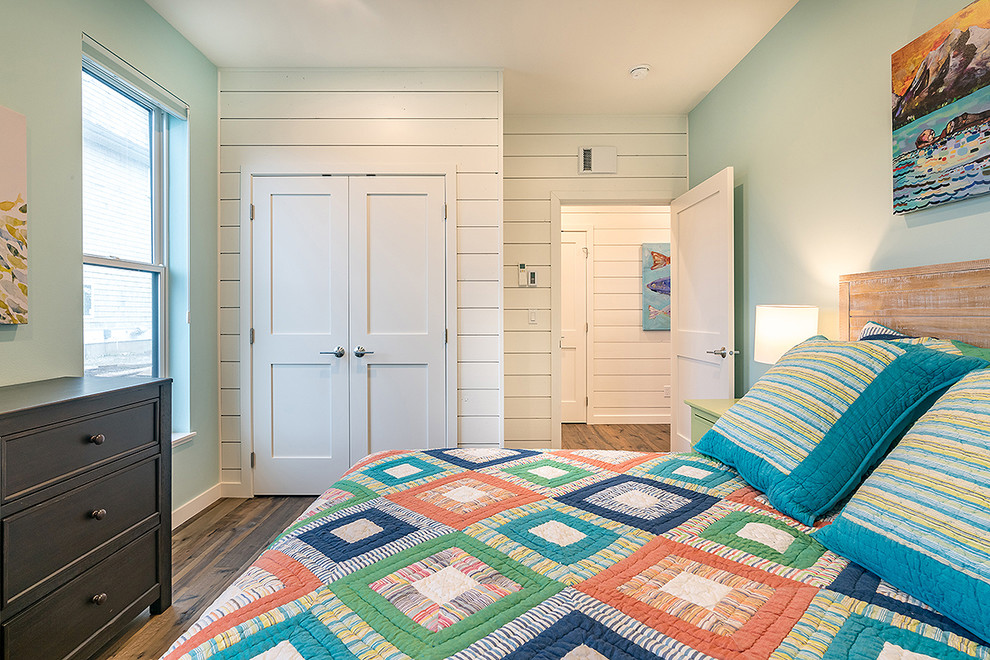 Ejemplo de habitación de invitados marinera de tamaño medio con paredes azules, suelo de madera en tonos medios y suelo marrón
