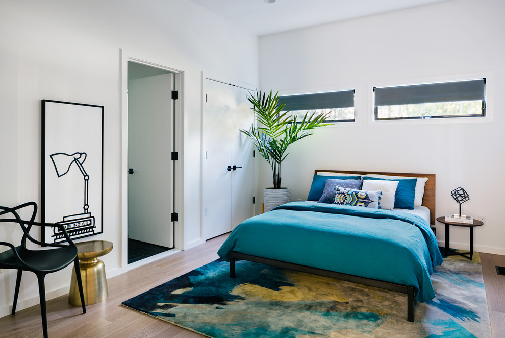 Immagine di una camera da letto minimal di medie dimensioni con pareti bianche, parquet chiaro e pavimento beige