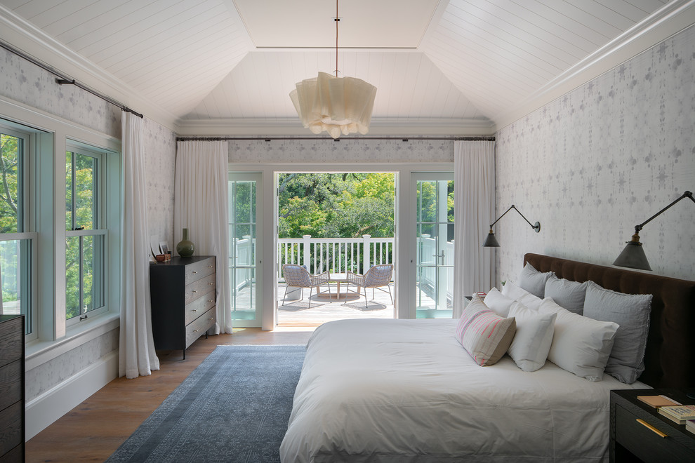 Foto de dormitorio principal clásico renovado grande sin chimenea con paredes blancas, suelo de madera en tonos medios y suelo marrón