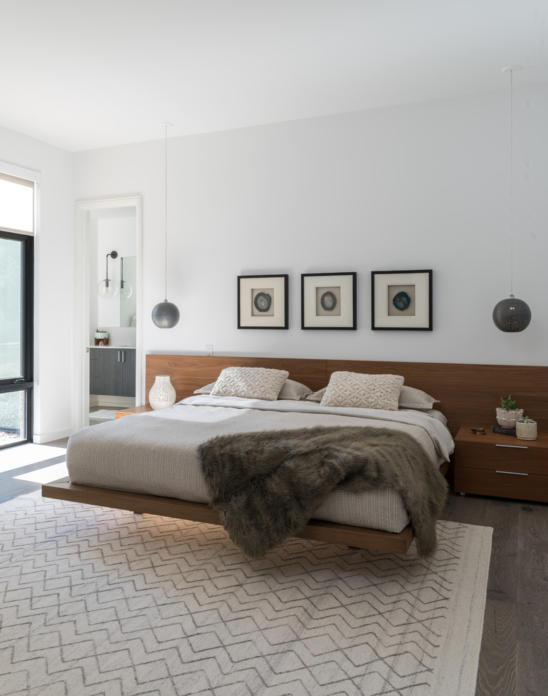 Example of a trendy master medium tone wood floor bedroom design in Dallas with white walls