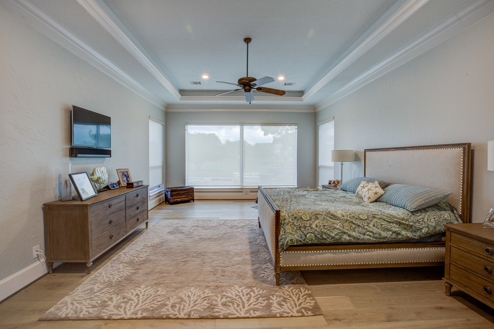 Diseño de dormitorio principal tradicional grande con paredes beige y suelo de madera en tonos medios