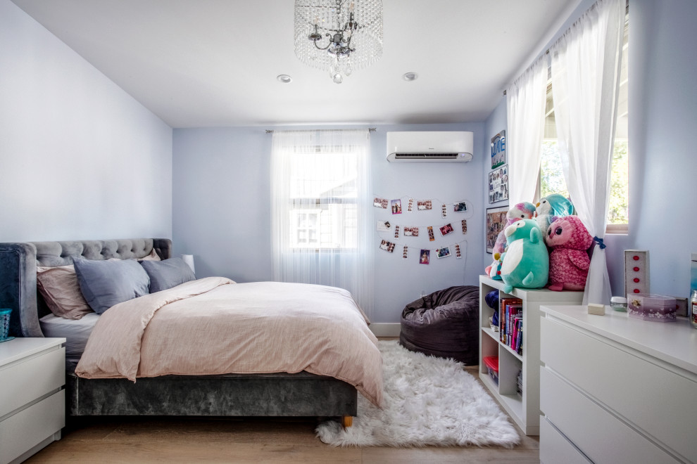 Exemple d'une chambre d'amis tendance de taille moyenne avec un mur bleu, parquet clair, aucune cheminée et un sol marron.